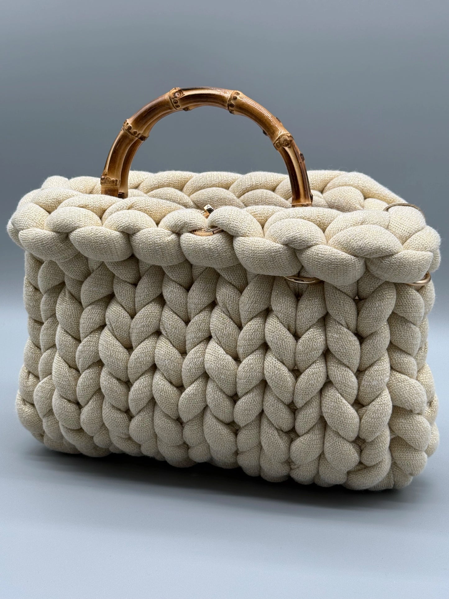 Hera Bag Medium in Cremeweiß mit Goldfaden – seitlich-frontal aufgenommenes Produktbild für die Produktseite, luxuriöse Handtasche aus Acrylic-Lurex-Garn