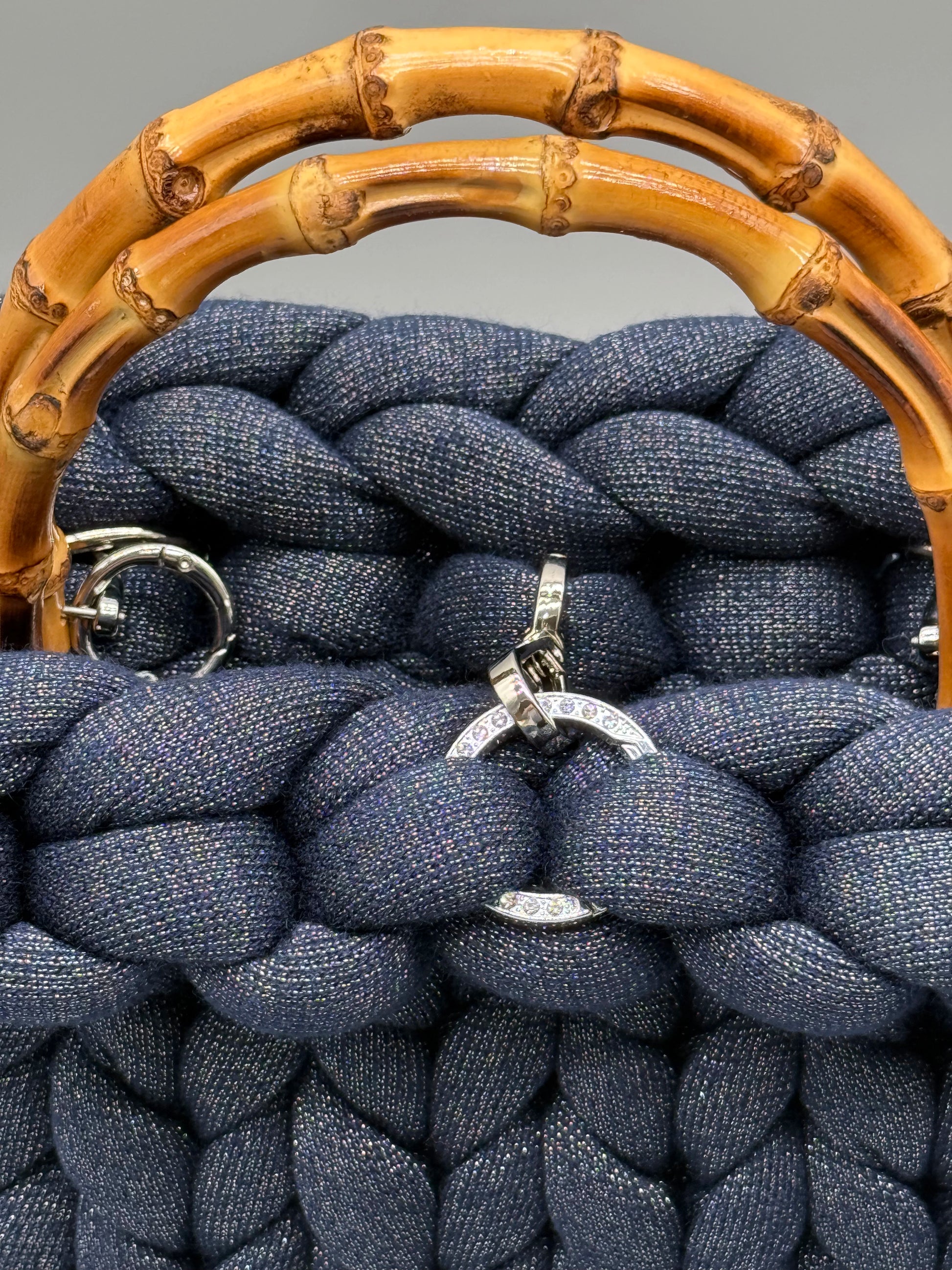 Detailaufnahme der Hera Bag: Silberfaden im Garn, goldene Schnalle und Bambusgriffe – feine Handarbeit und luxuriöse Materialien im Fokus