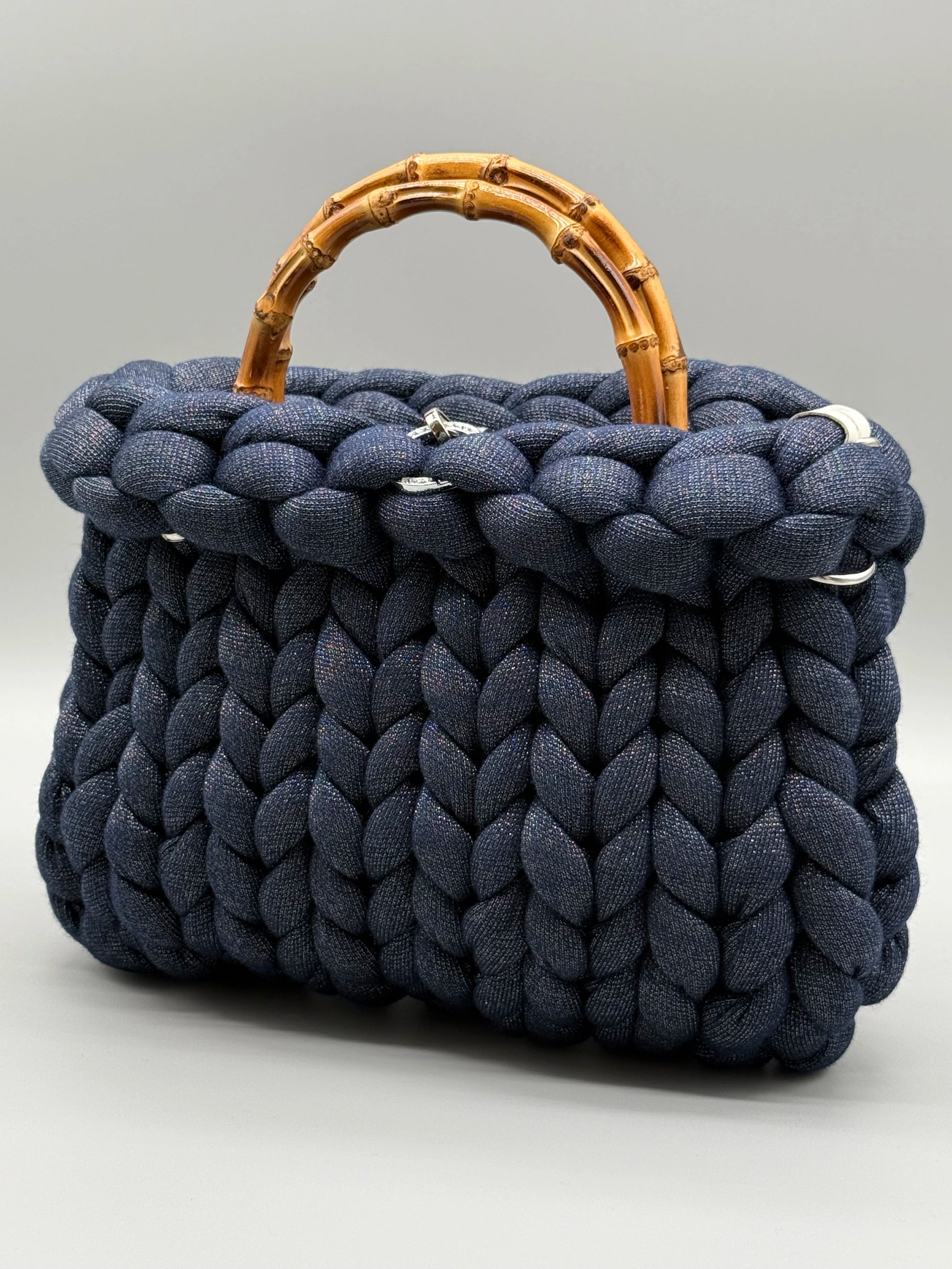 Hera Bag aus Acrylic-Lurex-Garn, frontal und leicht seitlich aufgenommen – luxuriöse Handtasche vor hellem Hintergrund in edler Verarbeitung