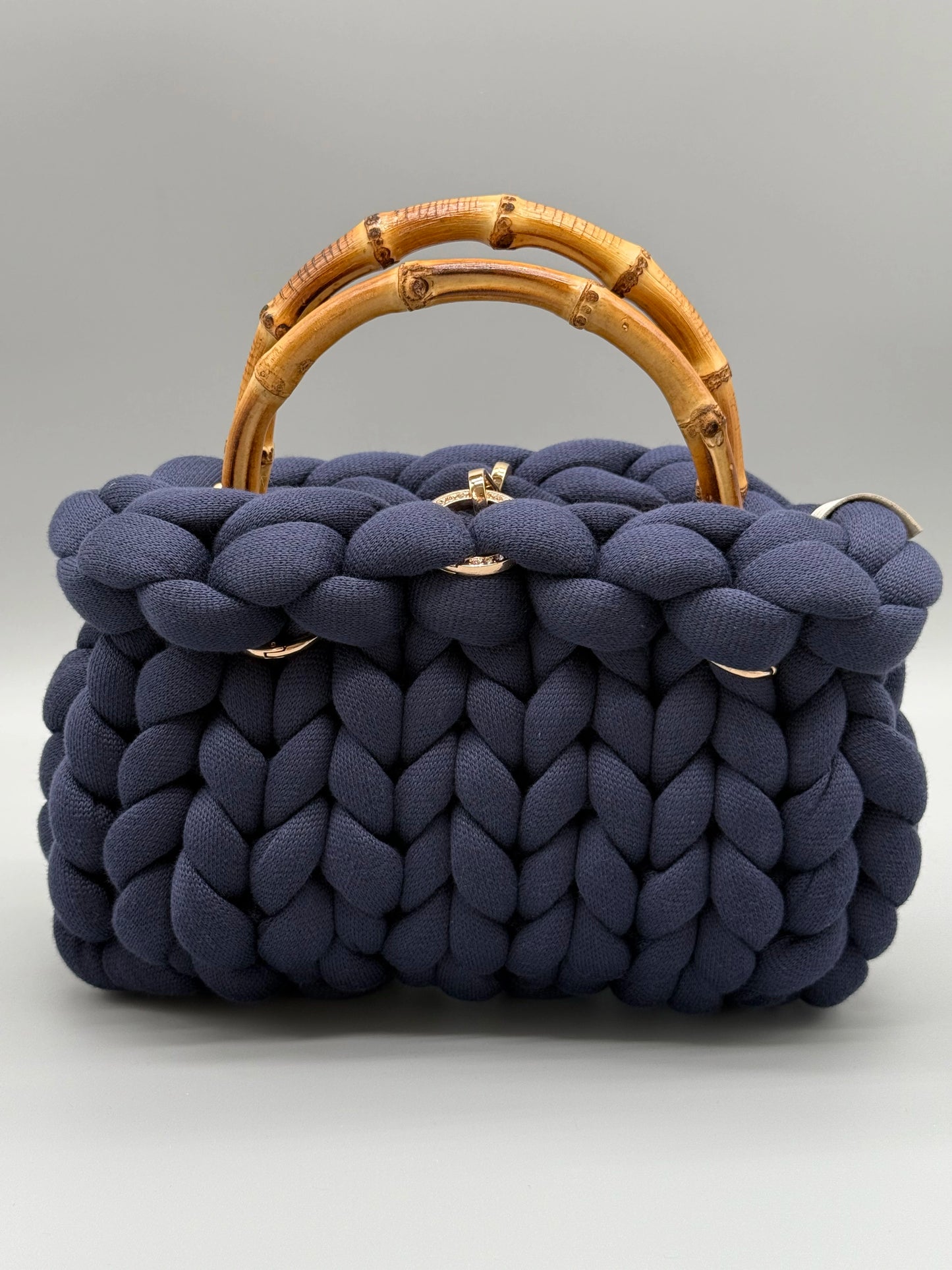 Handgefertigte Handtasche mit Bambusgriffen von vorne fotografiert auf einem hellen Hintergrund. 
