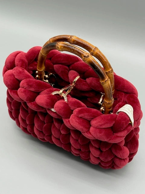 Hera Bag aus Samt in Bordeauxrot, seitliche Vogelperspektive, Farbe gut erkennbar, Produktbild auf hellem Hintergrund, luxuriöse Designerhandtasche